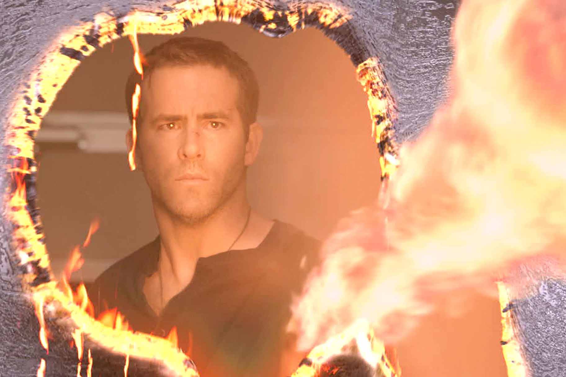 Damian (Ryan Reynolds) looks through a fiery hole in Self/Less (2015).