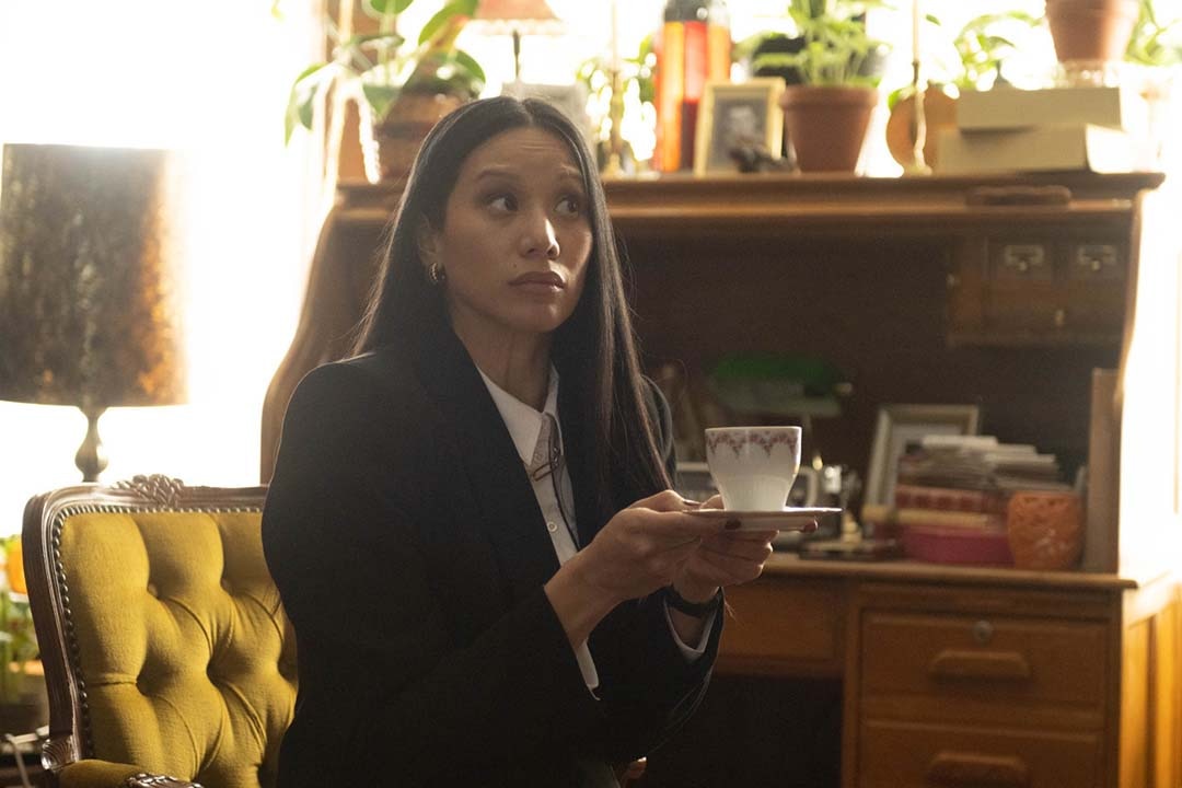 Lomax (Elena Juatco) sits with a teacup and saucer in SurrealEstate 207