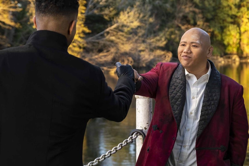 Reginald Andres (Jacob Batalon) fist bumps a man in Reginald the Vampire Episode 201.