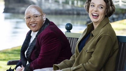 Reginald Andres (Jacob Batalon) and Sarah Kinney (Em Haine) sit and laugh in Reginald the Vampire Episode 201.