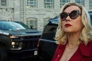 Tiffany (Jennifer Tilly) wears sunglasses and stands in front of trucks in Chucky 304.