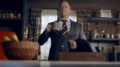 Harry Vanderspeigle wears a suit and holds a mug in Resident Alien Episode 301.