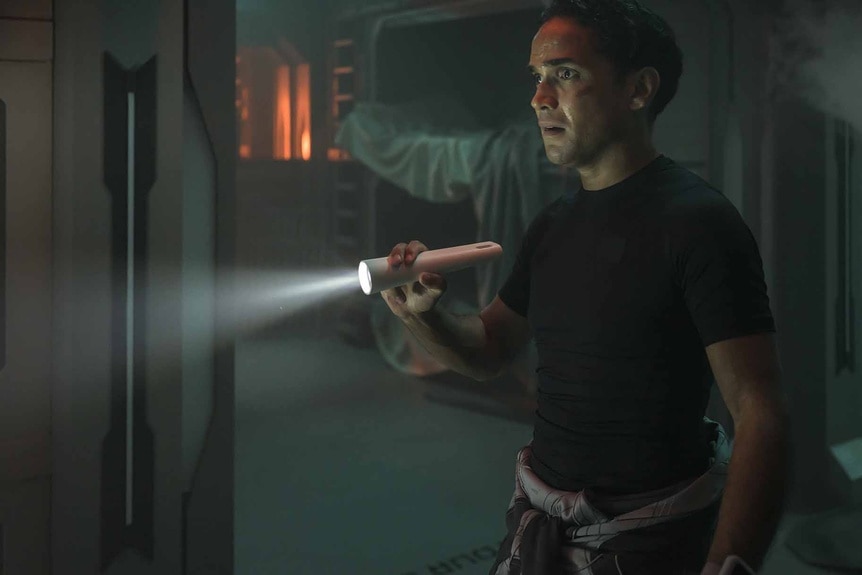 LT. Spencer Lane (Reece Ritchie) uses a flashlight on The Ark Season 2.