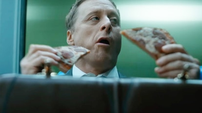 Harry Vanderspeigle (Alan Tudyk) eats pizza in Resident Alien Season 3 Episode 1.