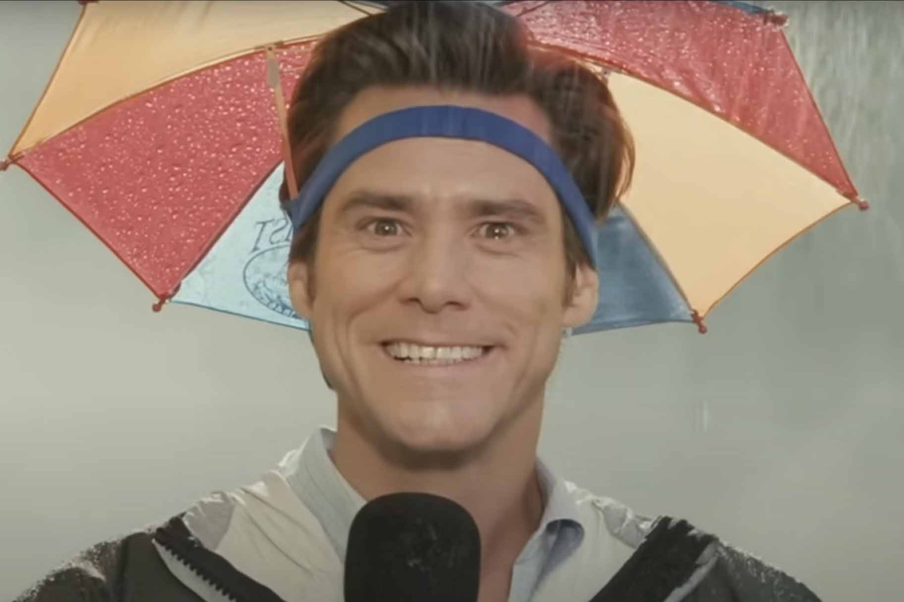 Bruce (Jim Carrey) smiles strangely in an umbrella hat in Bruce Almighty (2003).