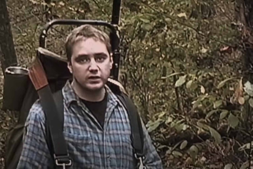 Michael C. Williams wears a hiking backpack in the woods in The Blair Witch Project (1999).