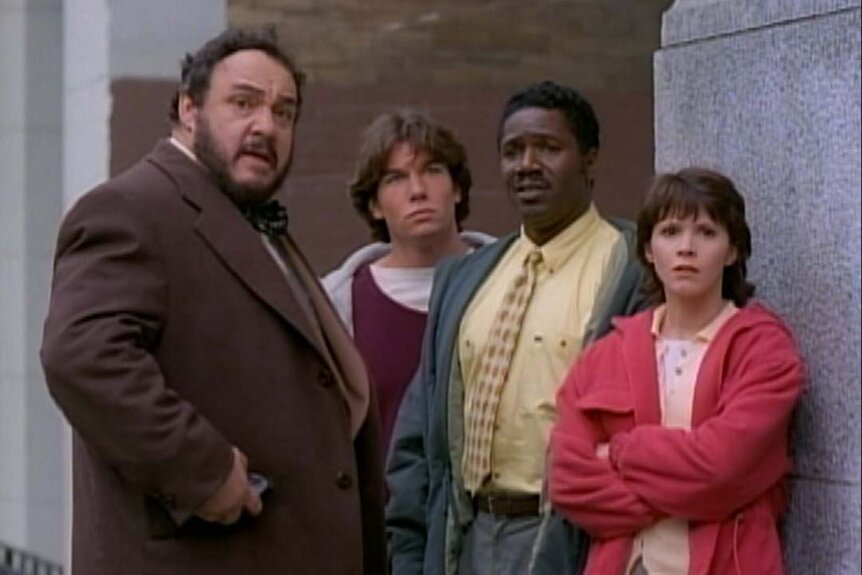 Professor Maxamilian Arturo (John Rhys-Davies), Quinn Mallory (Jerry O'Connell), Rembrandt "Crying Man" Brown (Cleavant Derricks), and Wade Welles (Sabrina Lloyd) stands in Sliders 103.